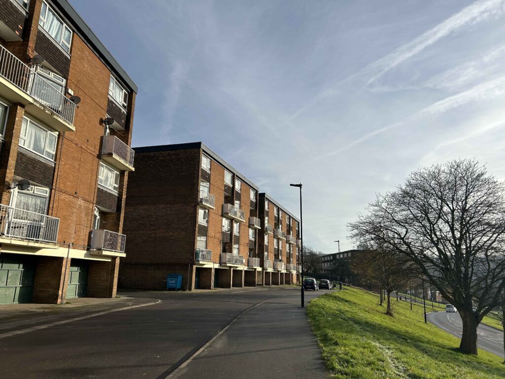 A block of flats on the Gleadless Valley estate with a grass verge next to it.