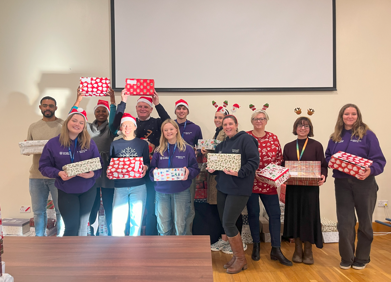 Volunteers holding wrapped shoeboxes