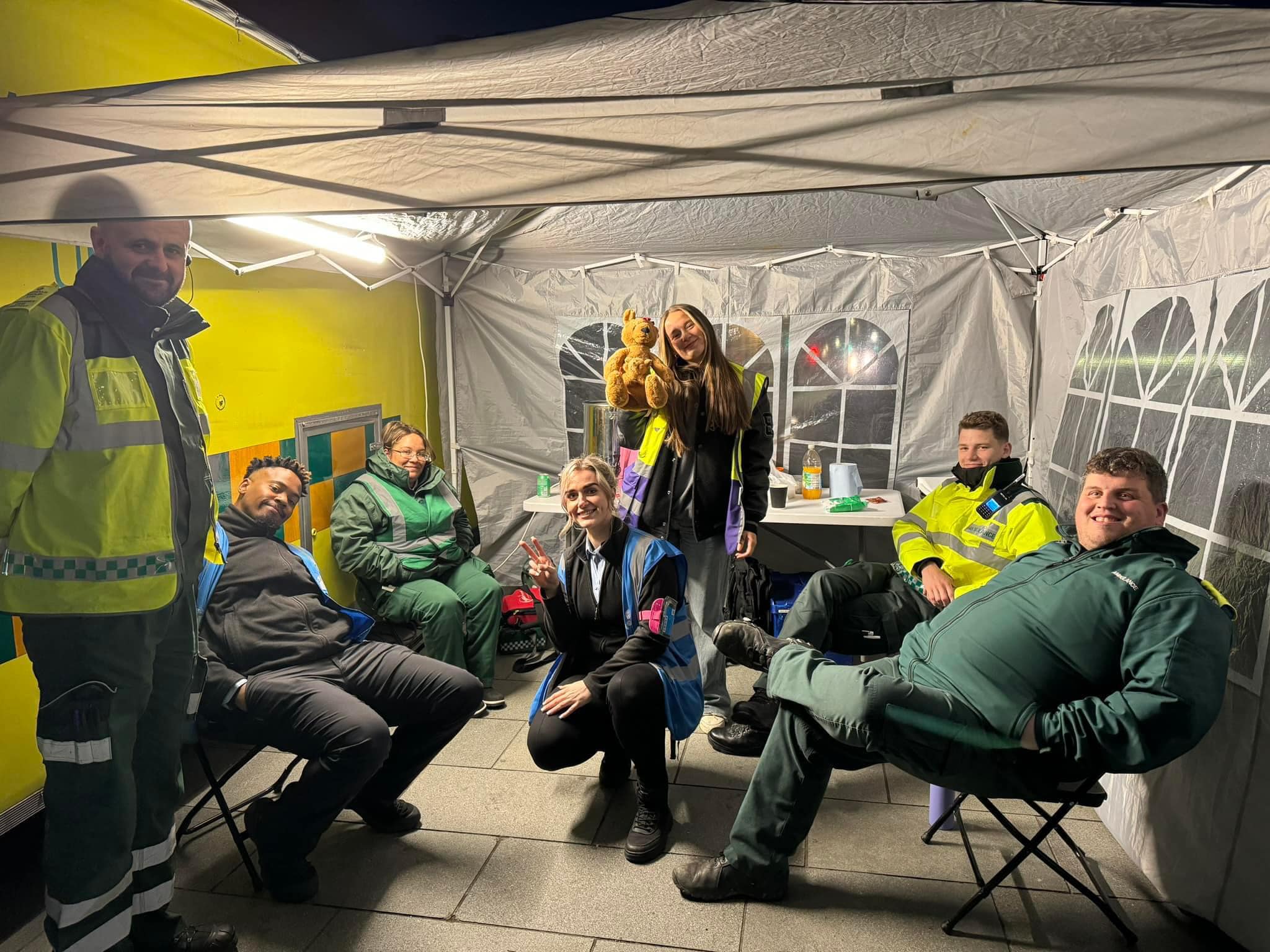 The Safe Square team gathered in a tent wearing reflective vests.