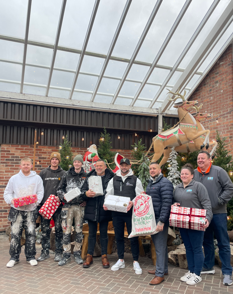 Business owners pose with presents. 