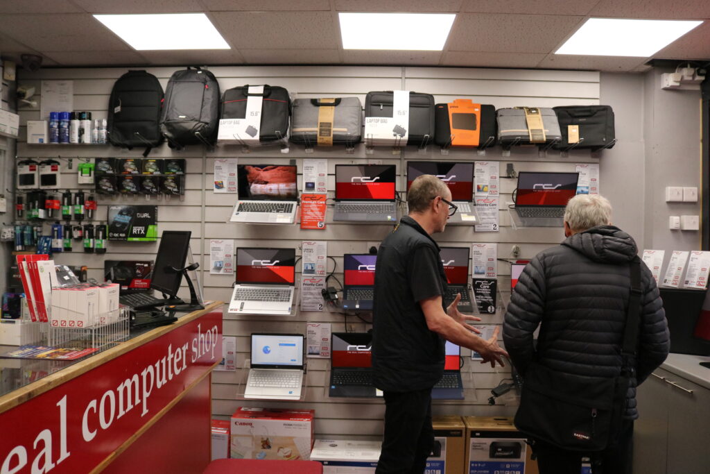 Nick Dutch, Director of the Real Computer Shop on Ecclesall Road, Sheffield, shows a customer his selection of refurbished laptops.