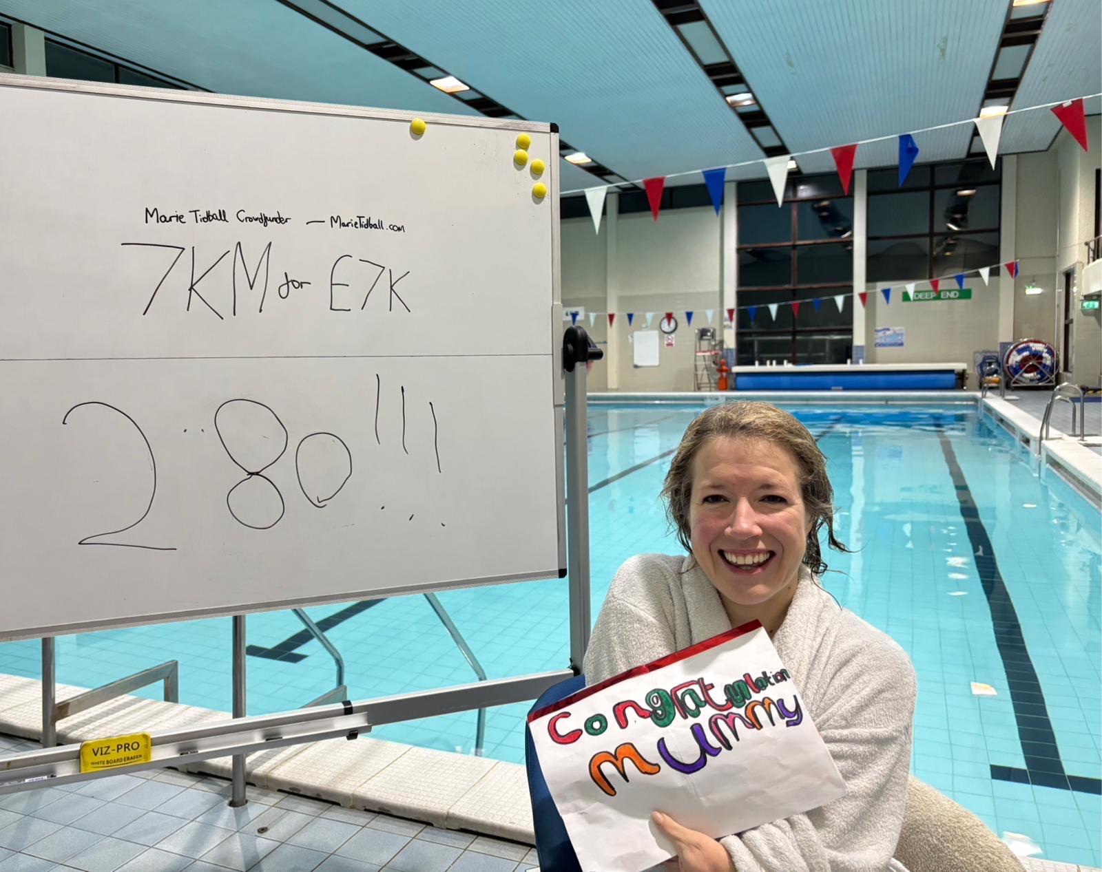 5fb28ec1-fd52-4a38-a50c-4e2ce7ce5bb9 Marie Tidball MP at the end of her 7km swim at Stocksbridge Community Leisure Centre, holding up a drawing done by her daughter.