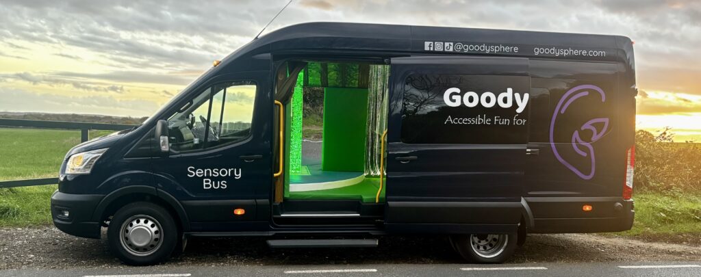The Goodysphere sensory bus- a black minibus with Goodysphere Accessible Fun for Everyone written across the door with a purple ear logo beside it. 