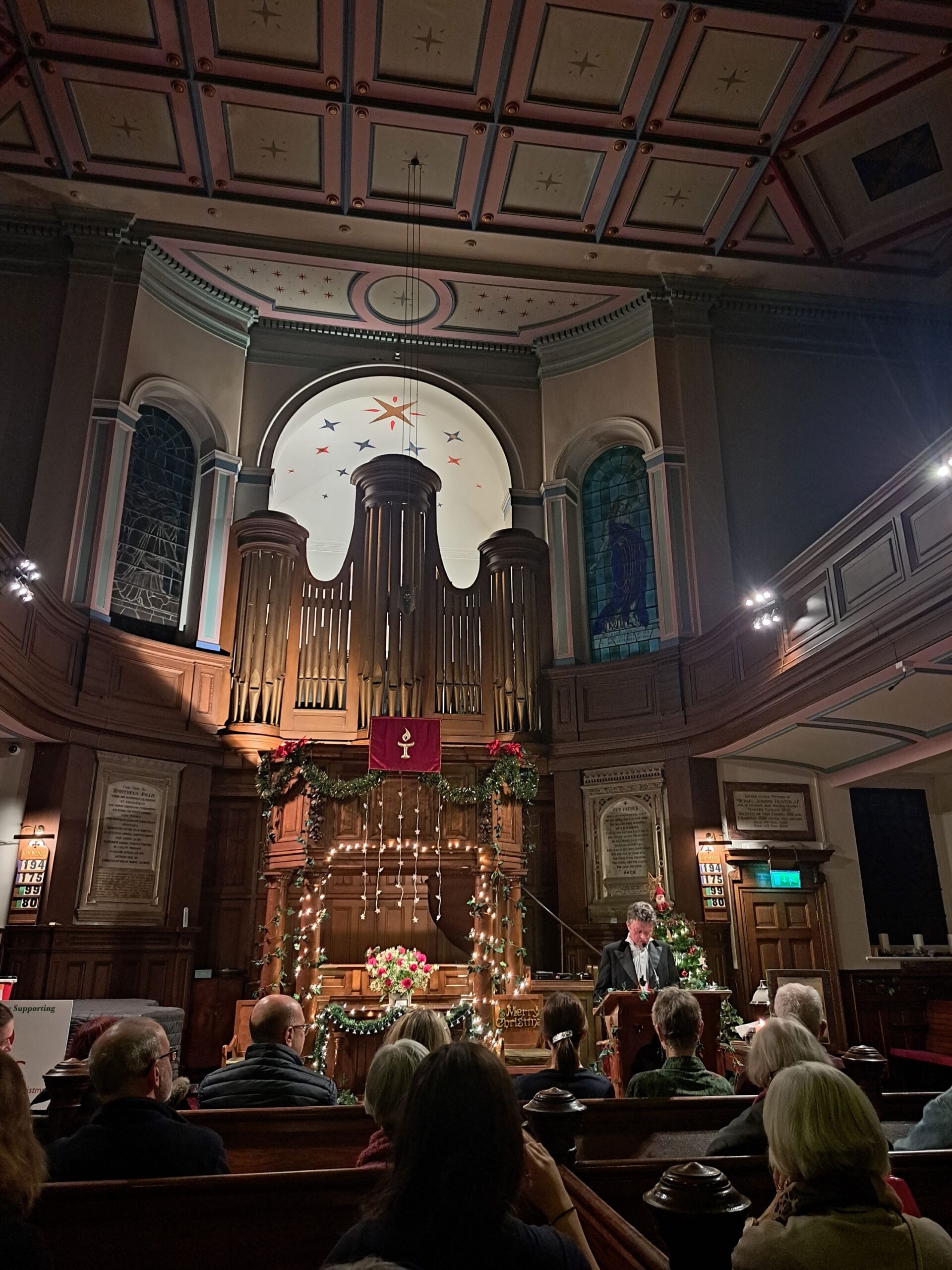 Patrick Smith, Chapel Manager of Upper Chapel, Sheffield reading A Christmas Carol to an audience in a festively decorated Victorian church